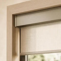 Roller shade tube and bracket seated inside a window reveal with a narrow clearance gap at the edge